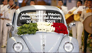 baby-blue vw bug, with flower garlands, serenaded by mariachi band